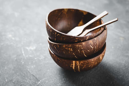Empty coconut bowl on gray background. Selective focus.の写真素材