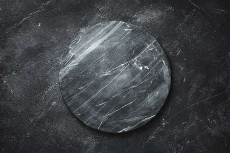 Round serving tray made of marble on a darkの写真素材