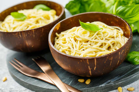 Delicious pasta with pesto sauce served in bowls of coconut. Close up.の写真素材