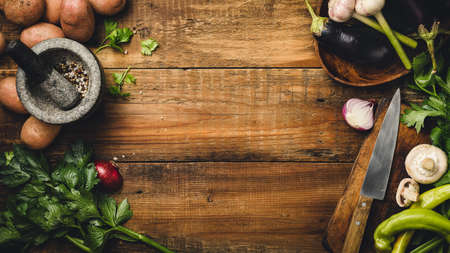 Ingredients for cooking raw vegetables on a wooden table, top view.の写真素材