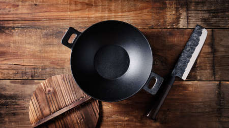 Empty cast iron wok and and knife, top view.の写真素材