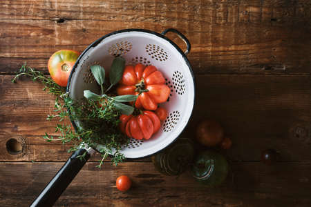 Farm tomatoes and herbs in a colanderの写真素材