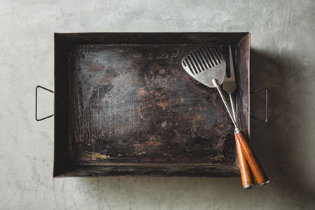 Empty baking sheet with fork and Spatula for Grill, Top view.の写真素材