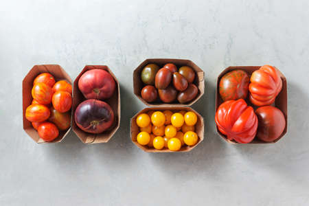 Cherry tomatoes and other varieties of tomatoes in little trays, Organic vegetablesの写真素材
