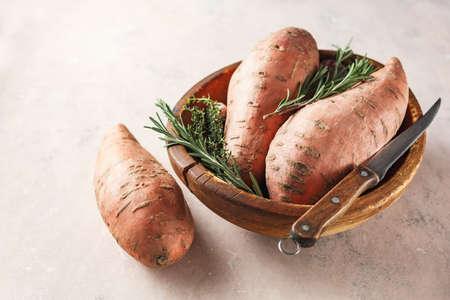 Organic sweet potatoes in a wooden bowlの写真素材