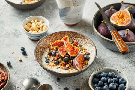 Cereal breakfast with fresh berries, seeds and figs in bowl.の写真素材