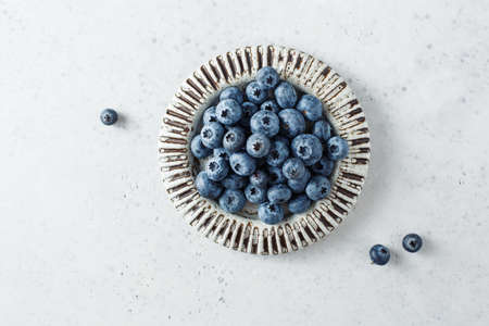 Fresh blueberries on a small ceramic plate. Top view, copy space.の写真素材