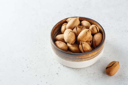 Fried pecan in bowls, on white background. Copy space.