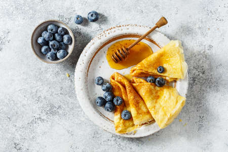 Crepes with honey and fresh blueberries.の写真素材