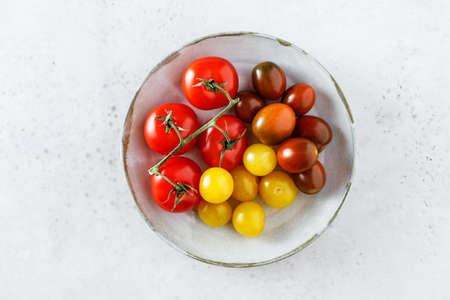 Delicious homegrown freshly picked tomatoes in a basket on the rustic wooden table. Outdoor.の写真素材