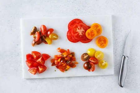 Different tomatoes cut in different ways. Ingredients for cooking.の写真素材