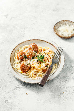 Spaghetti with meatballs and tomato sauce served with herbsの写真素材