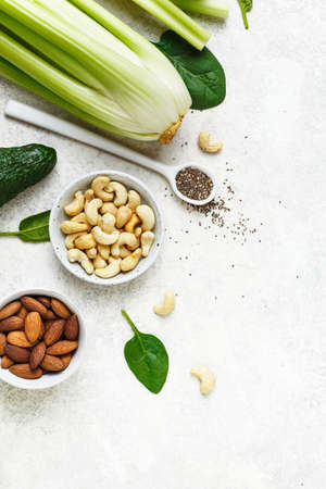 Ingredients for green smoothies celery, spinach and nuts. Top view.の写真素材