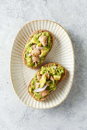 Avocado and tuna toasts on a plate, top view. Healthy food.の写真素材
