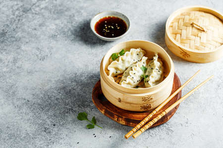 Delicious dumplings in bamboo steamer with sesame and cilantro.の写真素材