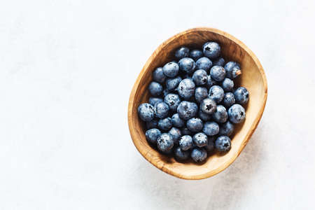 Fresh blueberries on a olive wood bowl.の写真素材