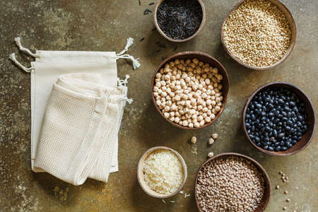 Eco cotton bags and organic grains and cereals in coconut bowlsの写真素材