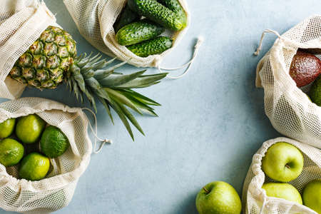 Organic green vegetables and fruits in reusable bagsの写真素材