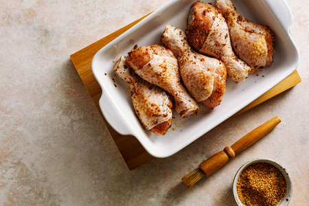 Raw marinated chicken drumstick prepared for baking.の写真素材