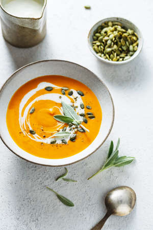 Creamy pumpkin soup with pumpkin seed and fresh herbs.の写真素材
