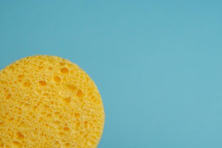 Yellow cosmetic sponge for washing on a blue backgroundの写真素材