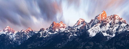 Sunrise Alpenglow Light on Beautiful Snowcapped Mountainsの写真素材