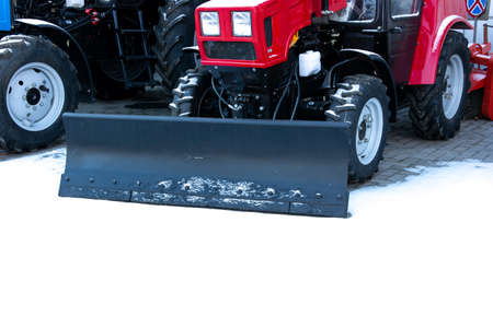 Red push tractor with shovel for snow cleaning