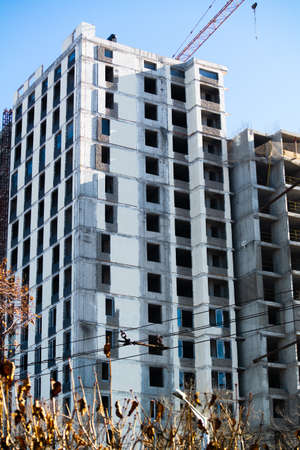 Unfinished building construction in the city tall craneの写真素材