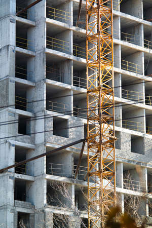 Unfinished building construction in the city tall craneの写真素材