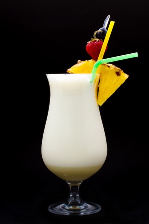 milk cocktail with pineapple and cherry on a black backgroundの写真素材