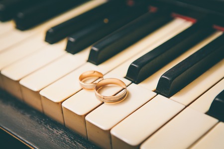wedding rings on a piano view at an angleの写真素材