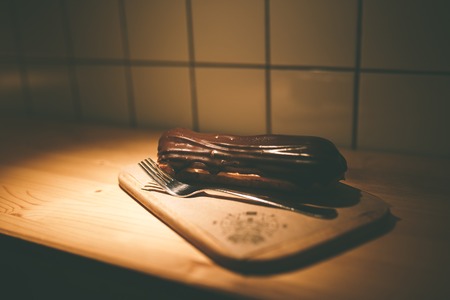 chocolate custard cream cake in a cafe on wooden table. Dessert on a white plateの写真素材