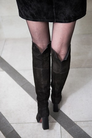 girl in high black boots, a coat in the office. lookbook, women's high leather bootsの写真素材