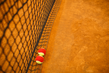 tennis red yellow ball on a clay tennis court orange colorの写真素材