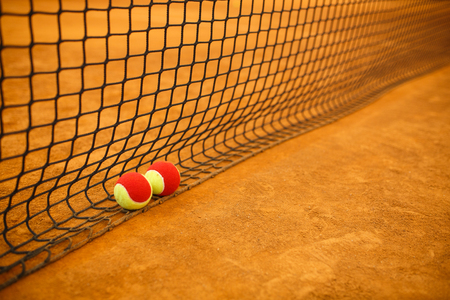 tennis red yellow ball on a clay tennis court orange colorの写真素材