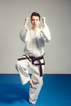 girl, Taekwondo is martial Stoke hands in fists, focused, serious look in the Studio on gray isolated backgroundの写真素材