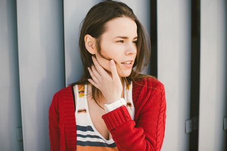 beautiful young girl smiling, is happy, happy , a red shirt over city gray metal wall backgroundの写真素材