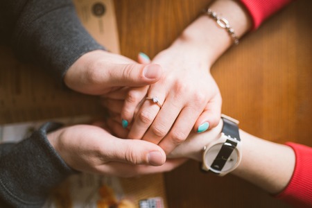 two pairs of hands in love tenderly hold together. love the conceptの写真素材