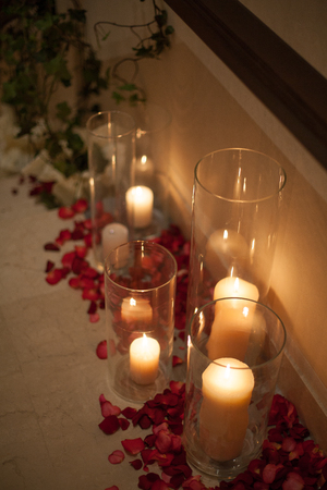 white candle in glass, red roses, romance is in the interiorの写真素材
