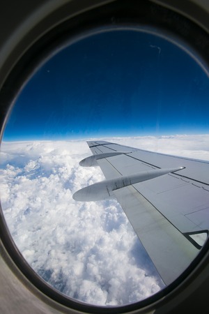 View from airplane window with blue sky and white clouds. Sunny weatherの写真素材