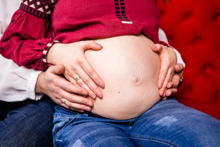 Father holds his pregnant wife by the hand. Close-up, Christmas atmosphereの写真素材
