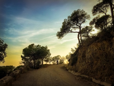 cyclist man riding a mountain bike at sunset day mountain tibidabo in Spain city of Barcelonaの写真素材