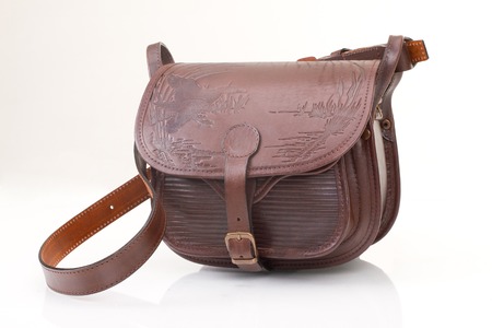 Leather hunting bag with brown ornament with patronage on white isolated background.の写真素材