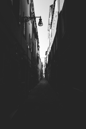 Beautiful view of a picturesque narrow alley with historic traditional houses and cobbled streets in the old city in Europe with blue sky and clouds in summer in Italy Venice.の写真素材
