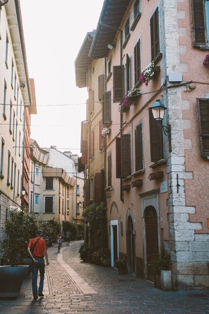 Old European street with architecture in italy in the evening on the shores of Lake Lago di garda city saloの写真素材