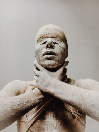 in makeup, a woman in bandages and clay is like a mummy without eyes on a monophonic background. Halloween themeの写真素材