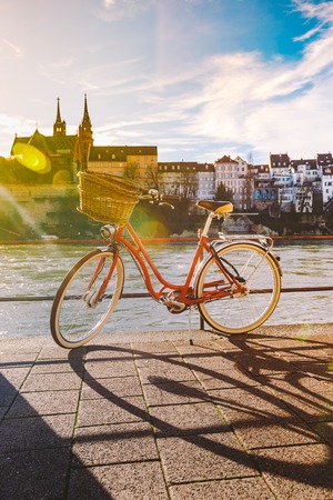 city bicycle with a basket on the steering wheel of red color on the quay near the river Rhine in...