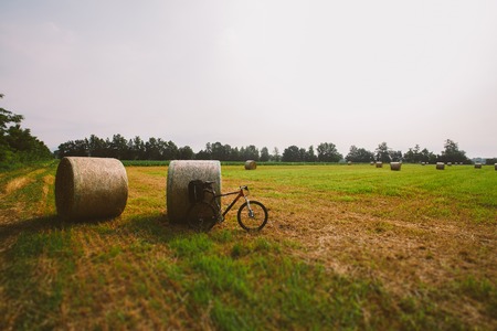 Bicycle in the field with big round bales of straw.の写真素材
