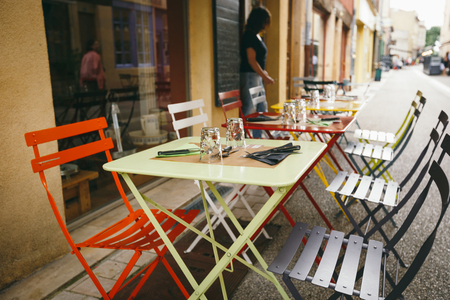 Theme cafes and restaurants. Exterior summer terrace of bright colors of street cafe shop in Europe in France. Preserved tables Without people, at tables nobody.の写真素材