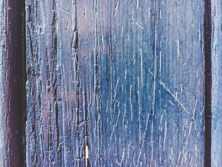 An old navy blue color of wooden wall with sun light for background texture.